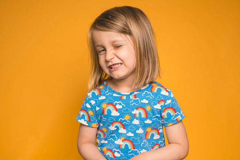 Kind im Fotostudio zu Hause vor gelben Hintergrund